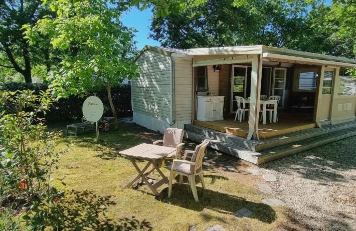 Mobile home avec terrasse et piscine.